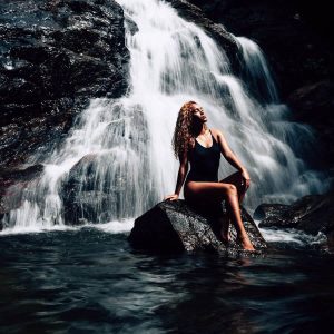 Model sitting in front of a waterfall